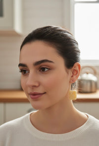 Close-up of noodle block resin earring worn on model's ear