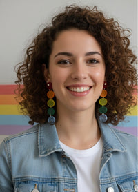 Model wearing rainbow acrylic circle drop earrings with curly hair and denim jacket