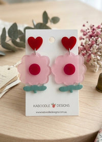 Pink flower heart stud earrings on a Kaboodle Designs card, showing red heart top and scalloped pink flower with teal stem