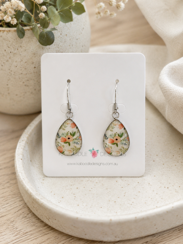 Teardrop floral dangle earrings on a Kaboodle Designs card, showing peach and green flower print in resin