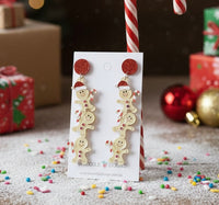Acrylic gingerbread man Christmas earrings on card with red glitter studs and candy cane props