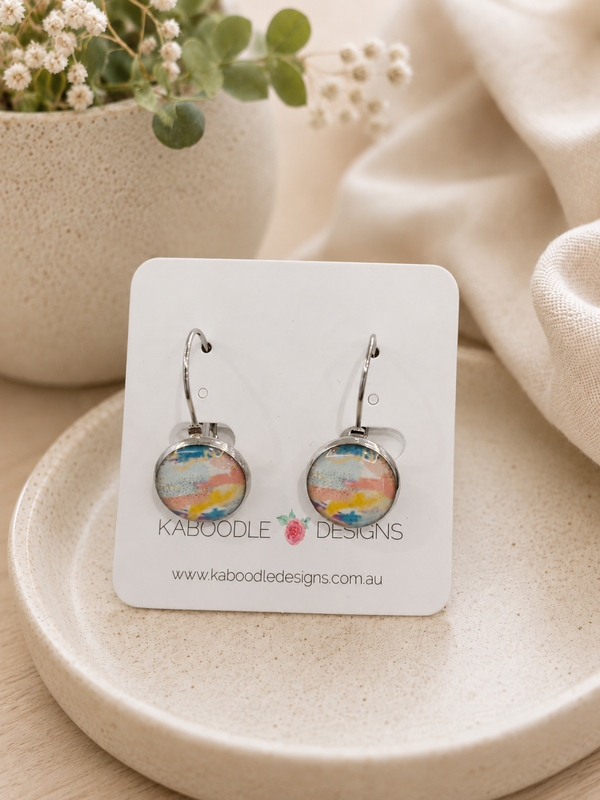 Round sorbet watercolour leverback earrings on a Kaboodle Designs card, showing pastel pink, blue and yellow abstract pattern