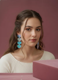 Translucent heart drop earrings worn on model's ear, side view
