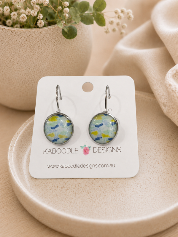 Round leverback earrings on Kaboodle Designs card, showing blue, green and yellow abstract print under glossy dome