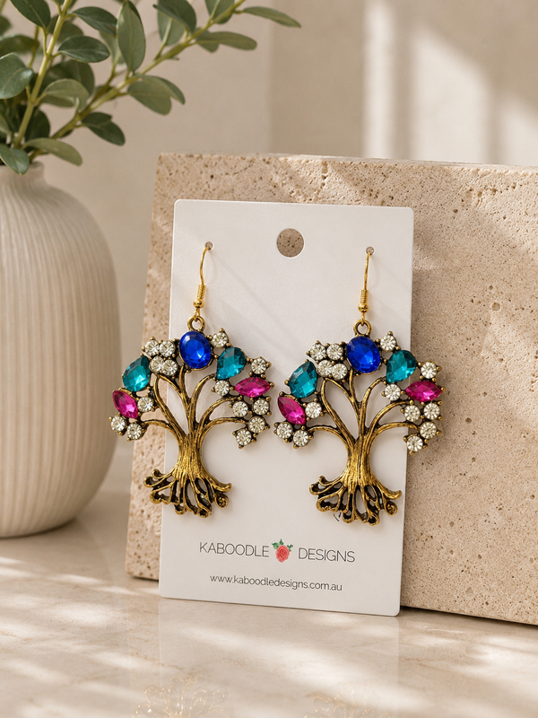 Antiqued brass tree of life earrings with blue, teal, pink and clear rhinestones on jewellery card