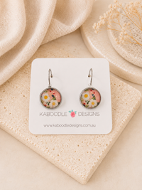 Round boho floral dangle earrings with pink and white daisy print on leverback hooks, shown on card