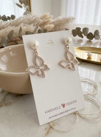 Pair of pearl and rhinestone butterfly earrings displayed on Kaboodle Designs card