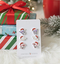 Set of 3 pairs kawaii Christmas character stud earrings on white card with festive gift wrap background