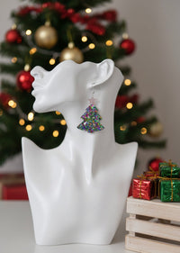 Close-up of glitter Christmas tree earring worn on ear, showing sparkle and star detail