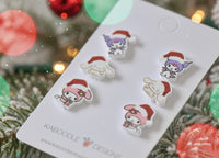 Overhead view of kawaii Christmas earring set on card with holly and bokeh light background