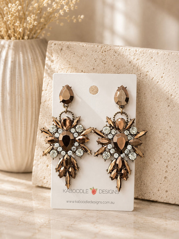 Bronze rhinestone statement drop earrings on Kaboodle Designs card, starburst design with clear crystal accents