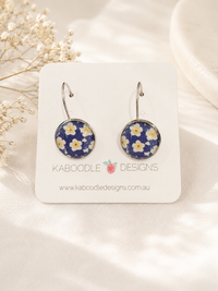 Round navy daisy print leverback earrings on Kaboodle Designs card, front view