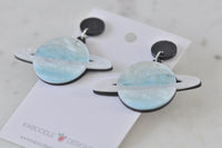 Blue Saturn drop earrings angled view showing black stud tops and gold flecks