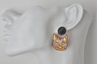 Close-up side view of cat face earring worn on ear mannequin