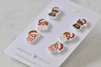 Angled view of all three dog earring pairs showing Santa hats and festive outfits on card