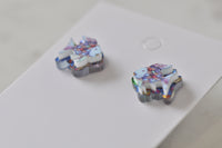 Angled view of two rainbow fish earrings showing glittery scale detail and stud backs