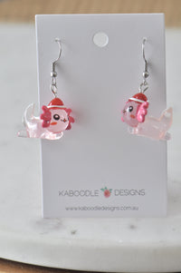 Pink axolotl Christmas earrings displayed on Kaboodle Designs card