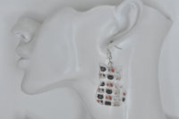 Single cat-shaped kitten face earring shown hanging from an ear for scale
