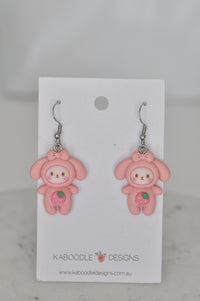 Pair of pink bunny-in-costume resin drop earrings with strawberry belly detail on Kaboodle Designs card