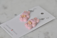 Pink bunny rabbit earrings lying flat on Kaboodle Designs card, side angle