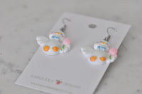 Close-up rear view of duck earrings showing wing and orange feet detail