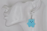 Blue bear drop earring shown worn on a model's ear for scale