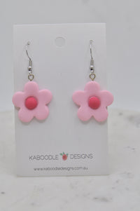 Pair of pink daisy-shaped resin drop earrings with pink centres on Kaboodle Designs card