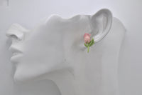 Pink tulip stud earring shown worn on ear for scale
