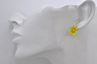 Yellow flower stud earring with red centre dots shown worn on a model's ear