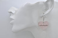 Pink heartbeat heart earring shown worn on ear for scale