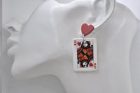 Queen of Hearts playing card earring shown hanging from a red heart stud on model's ear