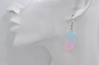 Single angel wing earring shown worn on ear for scale