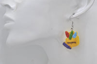 Close-up of crayon box earring worn on ear, showing glossy finish and CRAYONS text