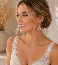 Bride wearing gold rhinestone butterfly earring styled with veil and lace dress