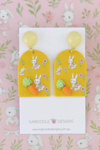 Mustard resin arch drop earrings with printed bunny and carrot design on card
