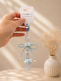 Close-up of beaded charm showing blue floral beads, clear crystals and bow shape