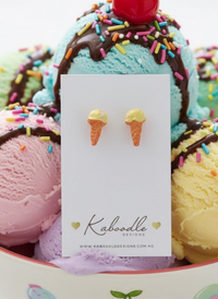Yellow ice cream cone stud earrings displayed on a white Kaboodle card against a bowl of ice cream