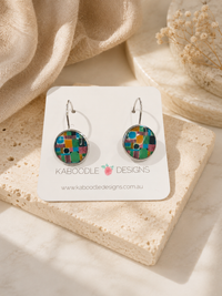 Round dangle earrings with colourful retro geometric print on a Kaboodle Designs card