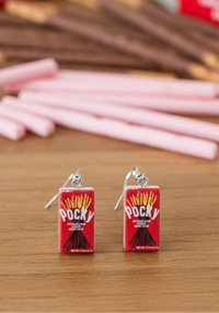 Pocky box earrings shown from the front on a wooden surface with pink wafer sticks in the background