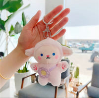 Pink plush sheep keychain held in hand showing silver clasp and keyring attachment