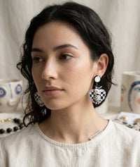 Woman wearing zebra checkerboard drop earring, side profile close-up