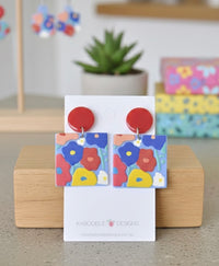 Square resin drop earrings with colourful geometric floral print on white display card