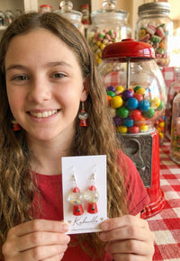 Close-up of model wearing one gumball machine earring, showing scale against the ear