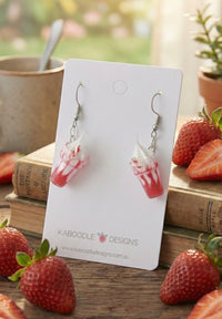Resin strawberry milkshake drop earrings on Kaboodle Designs card, red swirl with whipped cream top