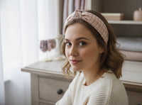 Woman wearing pastel pink checkered knot headband styled with wavy hair