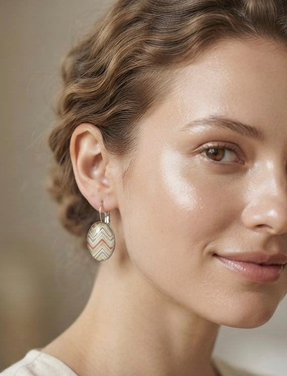 Close-up of model wearing rainbow chevron oval clip earring on ear