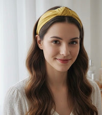 Model wearing mustard yellow knotted headband with wavy brown hair