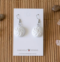 White resin bao bun dangle earrings on card, showing pleated swirl top detail