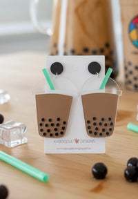 Acrylic boba milk tea drop earrings on card, tan cup with mint straw and black tapioca pearls