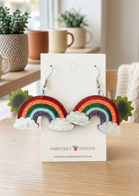 Rainbow cloud sun drop earrings on Kaboodle Designs card, front view showing sun peeking behind arch